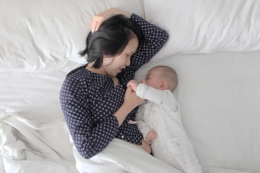 赤ちゃんと添い寝するママ