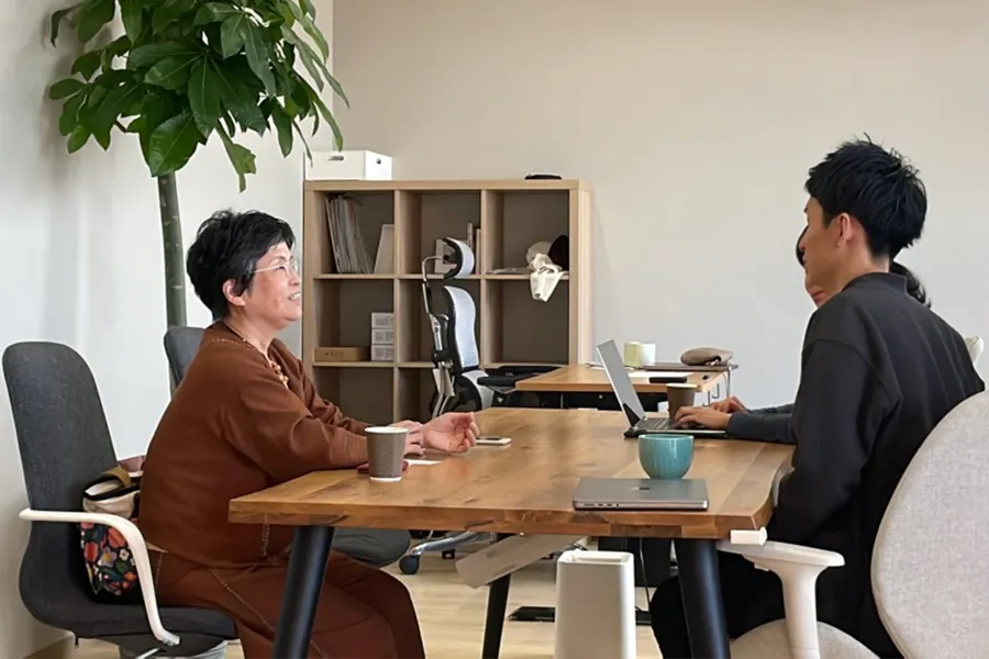 話す佐藤先生と話を聞く稲葉代表