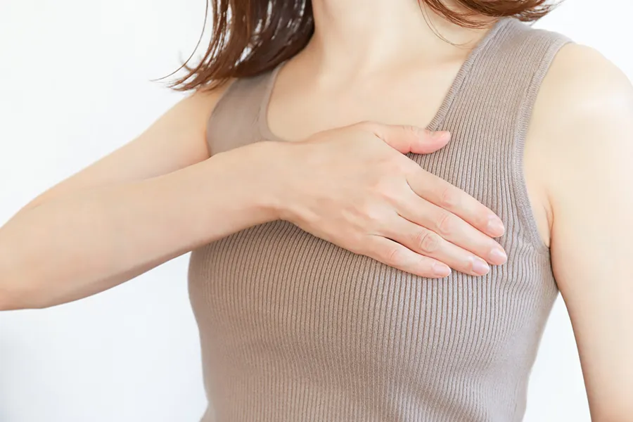 胸を押さえる女性